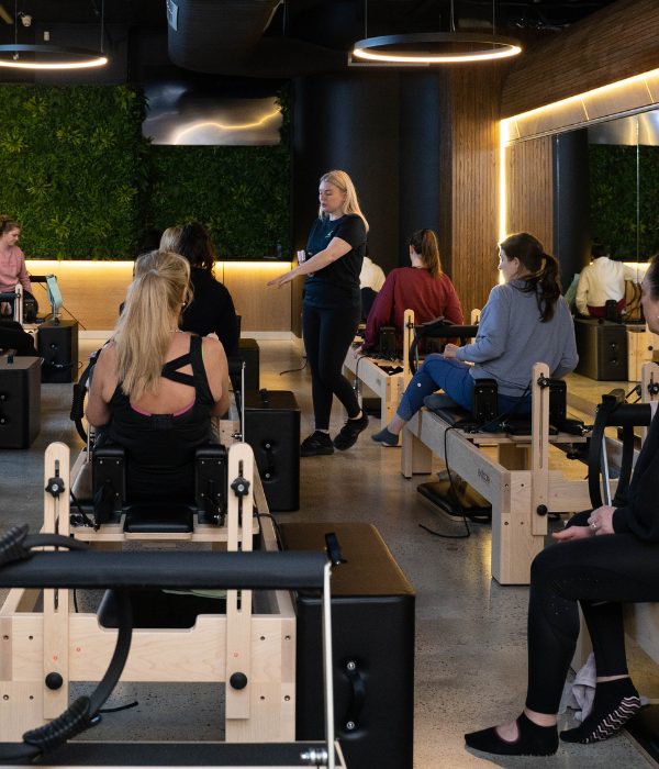 Instructor leading a full reformer Pilates class at 4ME Pilates Keilor Downs.
