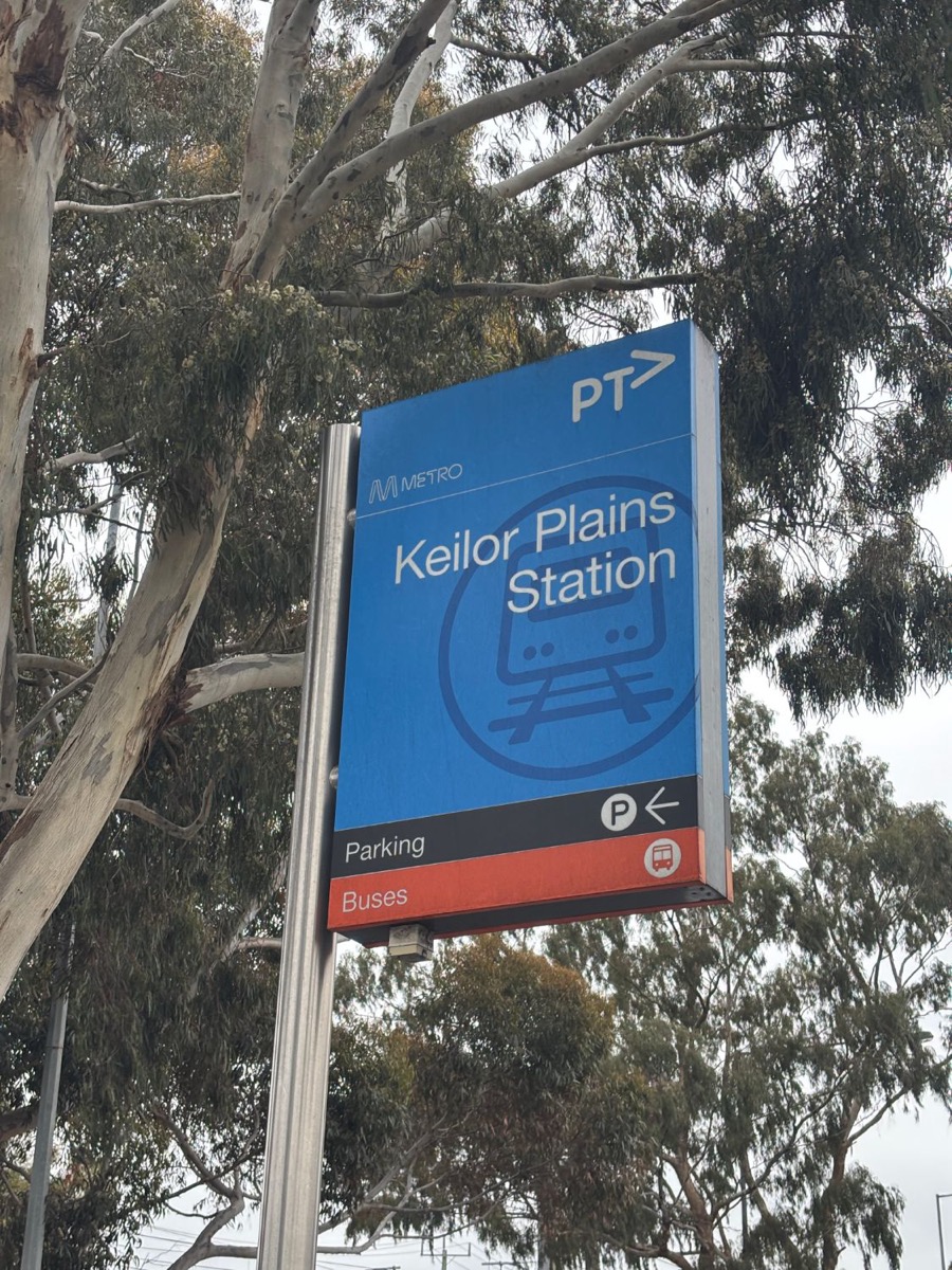 Keilor Plains Station sign under gum trees.